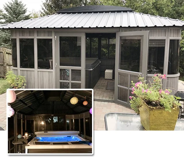 Wooden gazebo with screened windows, a hot tub inside, and a planter with flowers on the patio.