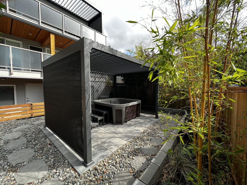 Outdoor Jacuzzi Under A Modern Pergola, Surrounded By A Stone Pathway, With Bamboo Plants Nearby.